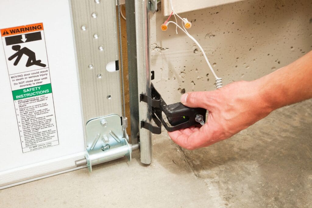 Technician installing auto reversal for garage door safety