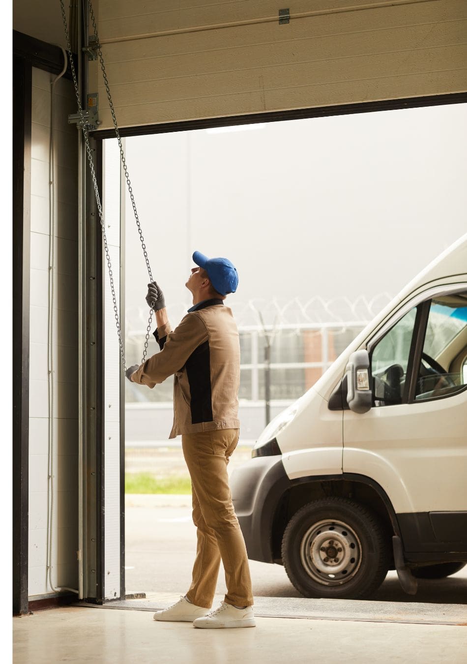 man pulling down garage door using chain
