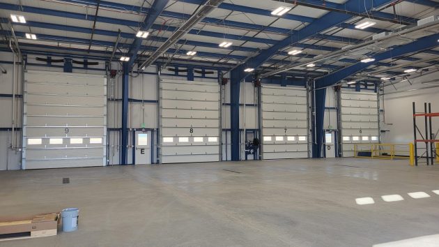 Inside of a commercial garage, showing several bays of garage doors.